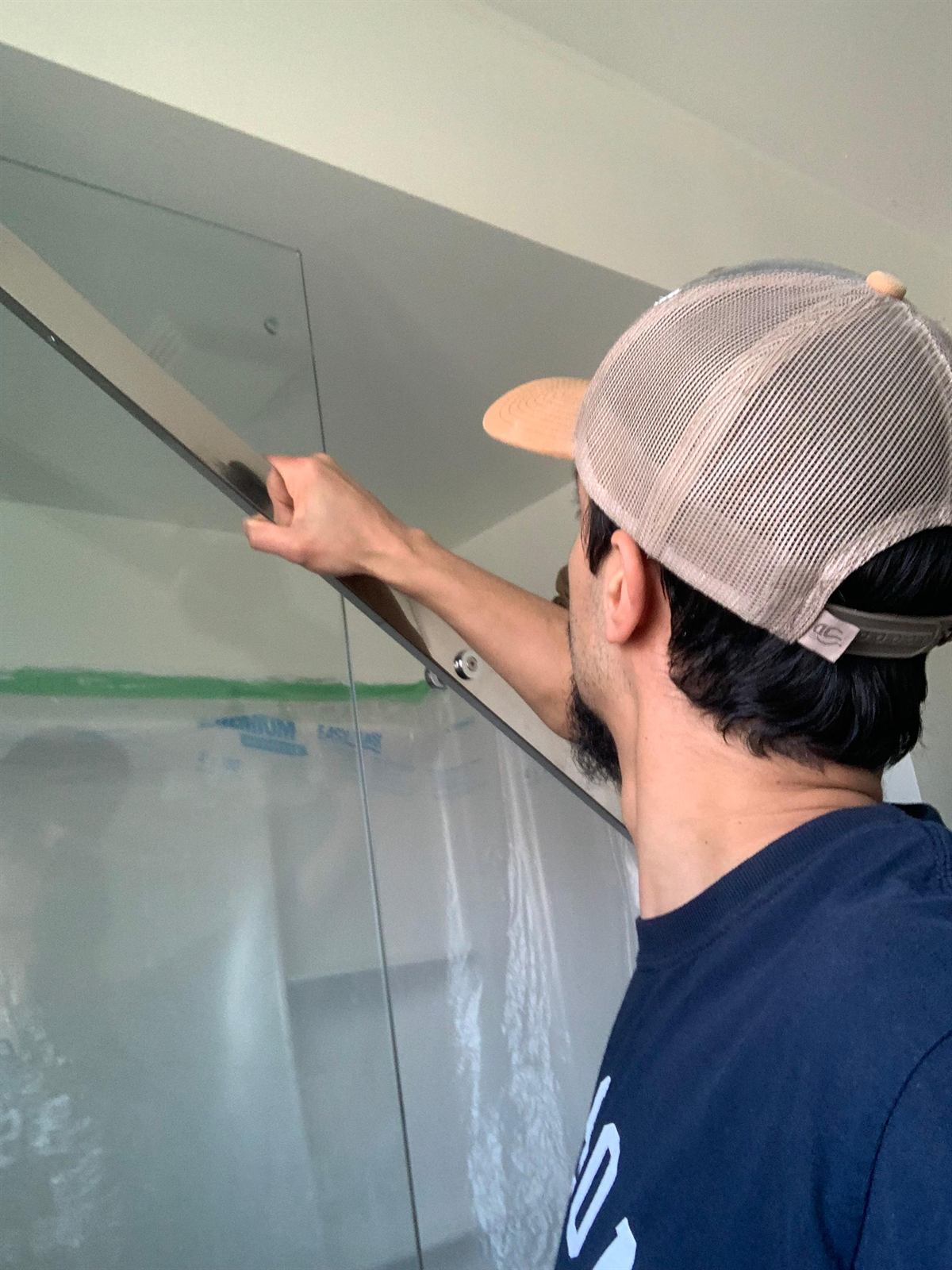 Meticulous wall painting using protective plastic containment to keep the home clean